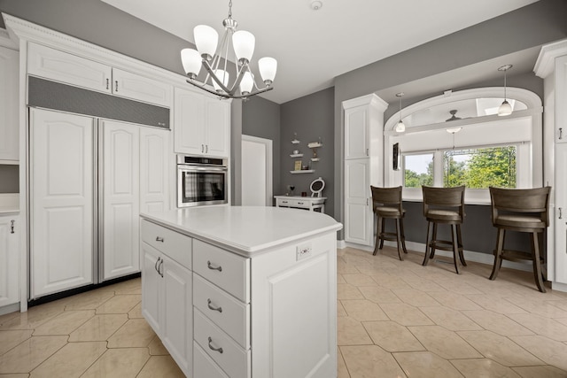 W3318 Lake Forest Ln, Lake Geneva, WI 53147 - kitchen with paneled built in fridge, stainless steel oven, a chandelier, white cabinetry, and light tile patterned floors