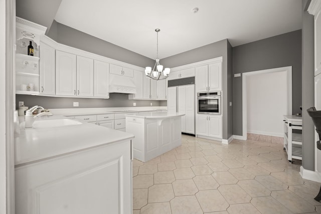 W3318 Lake Forest Ln, Lake Geneva, WI 53147 - kitchen with oven, paneled built in refrigerator, custom exhaust hood, a chandelier, and white cabinetry