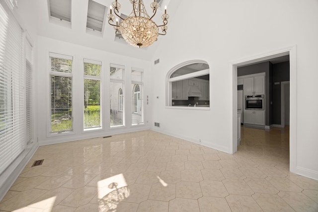 W3318 Lake Forest Ln, Lake Geneva, WI 53147 - empty room featuring a chandelier, a high ceiling, light tile patterned floors, and beam ceiling