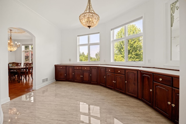 W3318 Lake Forest Ln, Lake Geneva, WI 53147 - kitchen featuring a chandelier, arched walkways, ornamental molding, pendant lighting, and light countertops