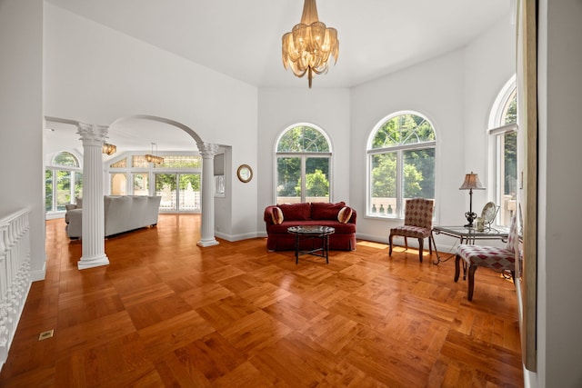 W3318 Lake Forest Ln, Lake Geneva, WI 53147 - living area with decorative columns, arched walkways, a chandelier, and a towering ceiling