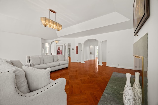 W3318 Lake Forest Ln, Lake Geneva, WI 53147 - living room featuring decorative columns, arched walkways, and a chandelier