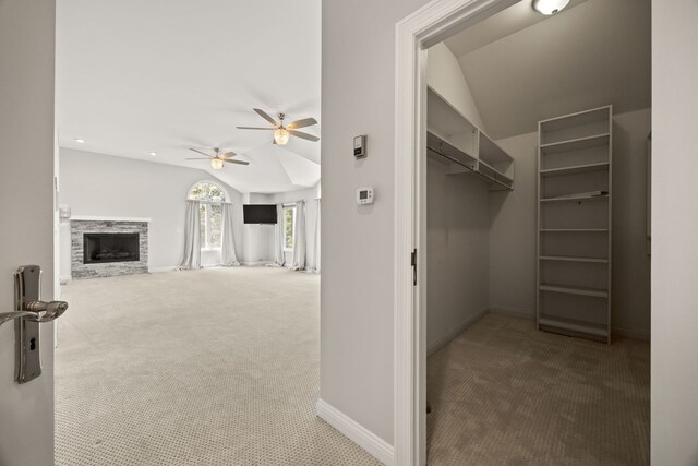 W3318 Lake Forest Ln, Lake Geneva, WI 53147 - spacious closet featuring carpet floors, lofted ceiling, a ceiling fan, and a stone fireplace