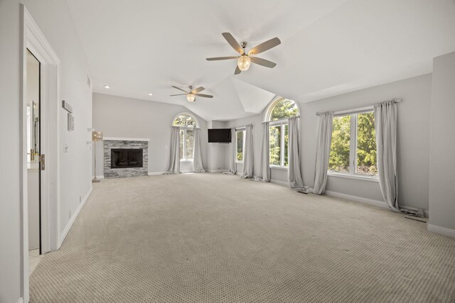 W3318 Lake Forest Ln, Lake Geneva, WI 53147 - unfurnished living room featuring plenty of natural light, carpet flooring, ceiling fan, vaulted ceiling, and a stone fireplace