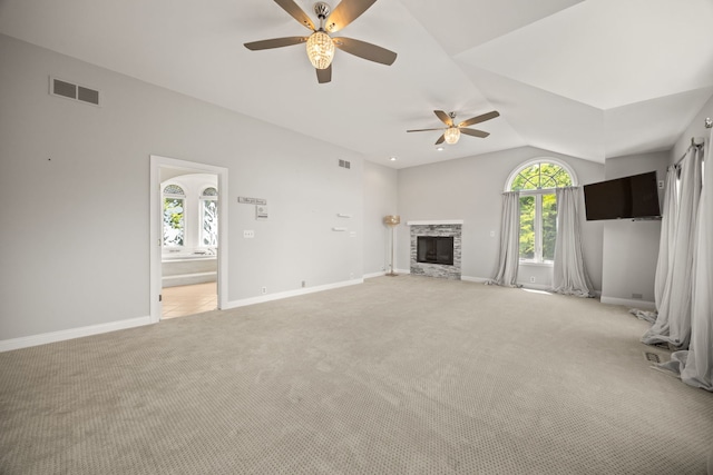 W3318 Lake Forest Ln, Lake Geneva, WI 53147 - unfurnished living room featuring a ceiling fan, light colored carpet, lofted ceiling, and a stone fireplace