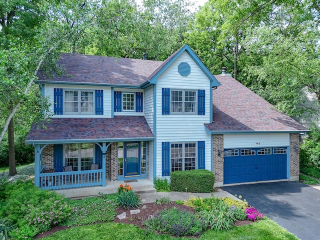 462 Kelly Ln, Crystal Lake, IL 60012 - traditional-style home with a porch, brick siding, an attached garage, driveway, and a shingled roof