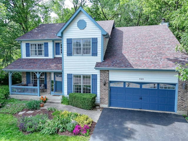 462 Kelly Ln, Crystal Lake, IL 60012 - traditional-style house featuring covered porch, a garage, driveway, roof with shingles, and brick siding