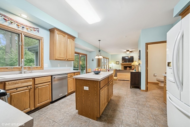 462 Kelly Ln, Crystal Lake, IL 60012 - kitchen with white fridge with ice dispenser, stainless steel dishwasher, a kitchen island, a warm lit fireplace, and plenty of natural light
