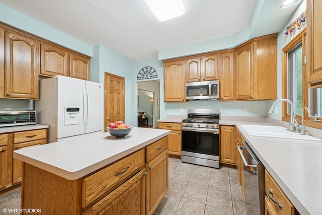 462 Kelly Ln, Crystal Lake, IL 60012 - kitchen featuring appliances with stainless steel finishes, light countertops, light tile patterned flooring, a center island, and brown cabinets