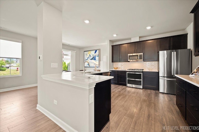 4116 Chelsea Manor Cir, Aurora, IL 60504 - kitchen featuring stainless steel appliances, light countertops, light wood-type flooring, decorative backsplash, and recessed lighting
