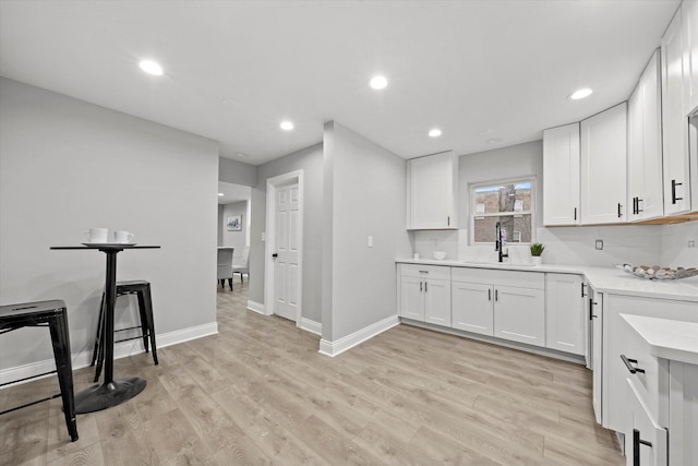 5241 W Adams St, Chicago, IL 60644 - kitchen featuring light countertops, recessed lighting, white cabinetry, light wood finished floors, and tasteful backsplash