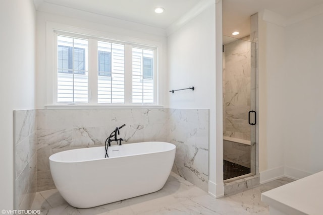 full bath with a soaking tub, a marble finish shower, marble tiled floors, wainscoting, and recessed lighting