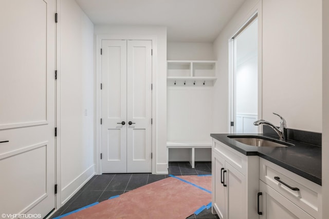 mudroom featuring a sink and dark tile patterned flooring