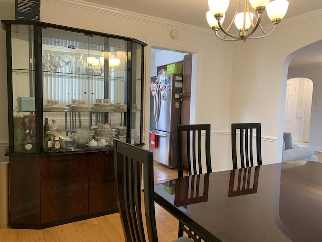4520 N Austin Ave, Chicago, IL 60630 - dining room featuring a chandelier, arched walkways, wood finished floors, and ornamental molding