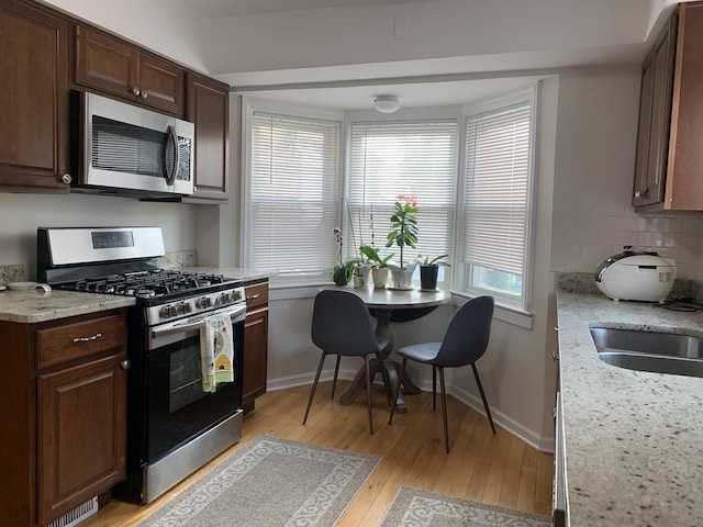 4520 N Austin Ave, Chicago, IL 60630 - kitchen with appliances with stainless steel finishes, light wood finished floors, healthy amount of natural light, and tasteful backsplash