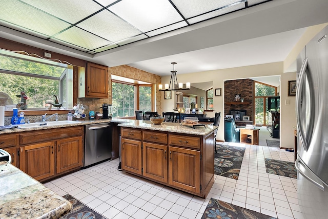 8414 W 119th St, Palos Park, IL 60464 - kitchen with appliances with stainless steel finishes, light tile patterned floors, brown cabinetry, and hanging light fixtures