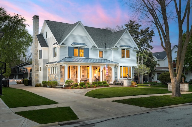 33 N Fremont St, Naperville, IL 60540 - view of front facade with roof with shingles, a standing seam roof, covered porch, driveway, and a front lawn