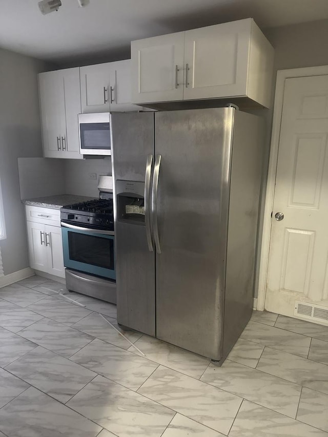 15818 Saint Louis Ave, Markham, IL 60428 - kitchen with appliances with stainless steel finishes, light marble finish flooring, and white cabinetry