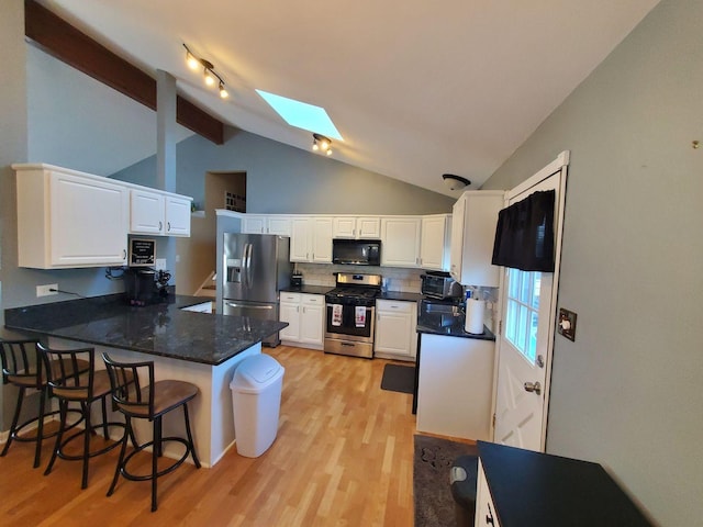 19707 S Skye Dr, Frankfort, IL 60423 - kitchen featuring appliances with stainless steel finishes, a skylight, a peninsula, and light wood-style flooring