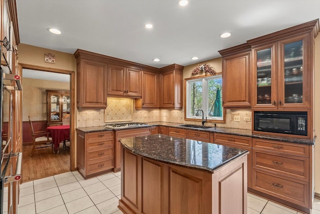 125 Grove Ln, Barrington, IL 60010 - kitchen with black microwave, brown cabinets, dark stone counters, light tile patterned floors, and glass insert cabinets