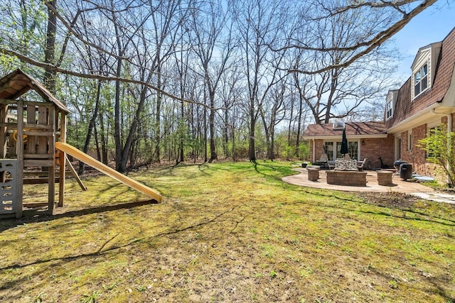 125 Grove Ln, Barrington, IL 60010 - view of green lawn featuring an outdoor fire pit, a playground, and a patio area