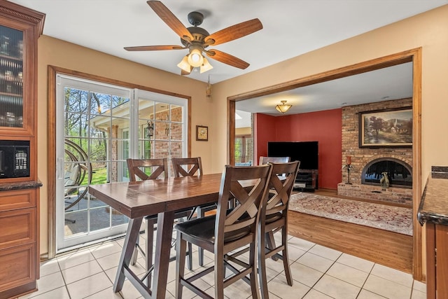 125 Grove Ln, Barrington, IL 60010 - dining room featuring light tile patterned floors, ceiling fan, and a brick fireplace