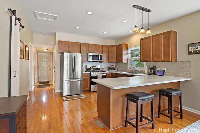 25134 W Lake Shore Dr, Ingleside, IL 60041 - kitchen featuring appliances with stainless steel finishes, a peninsula, decorative backsplash, brown cabinets, and recessed lighting