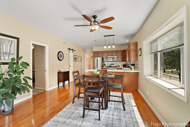 25134 W Lake Shore Dr, Ingleside, IL 60041 - dining area featuring light wood-type flooring, a barn door, and a ceiling fan