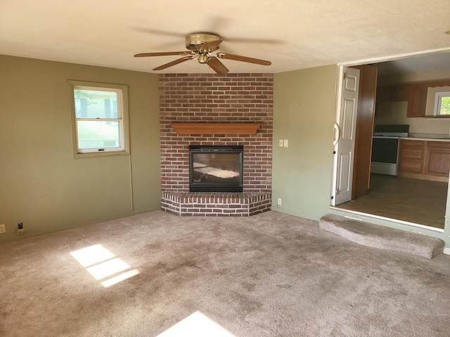 67 S Somonauk Rd, Cortland, IL 60112 - unfurnished living room featuring a ceiling fan, a brick fireplace, and carpet
