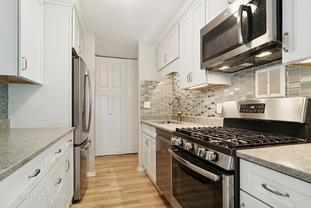 1127 S Old Wilke Rd Unit 201, Arlington Heights, IL 60005 - kitchen with stainless steel appliances, white cabinetry, light wood-style flooring, and tasteful backsplash