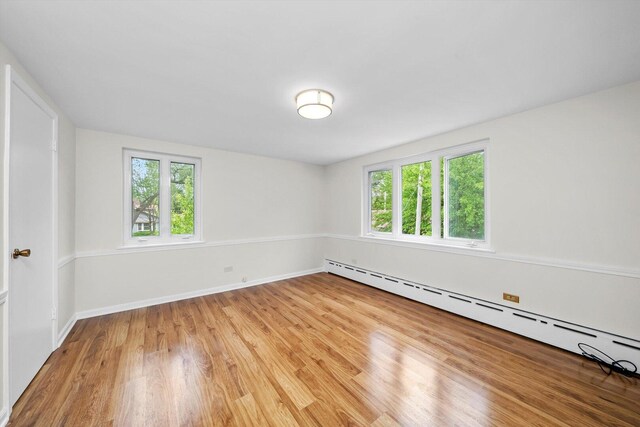 9209 S Hoyne Ave, Chicago, IL 60643 - spare room featuring a baseboard radiator, plenty of natural light, and light wood-type flooring