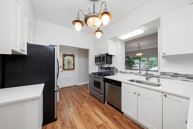 9209 S Hoyne Ave, Chicago, IL 60643 - kitchen featuring stainless steel appliances, tasteful backsplash, white cabinets, light wood-style floors, and a chandelier