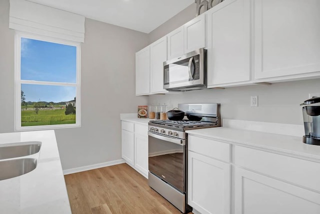 1511 Aspen Ln, Pingree Grove, IL 60140 - kitchen with appliances with stainless steel finishes, light wood-style flooring, light countertops, and white cabinetry