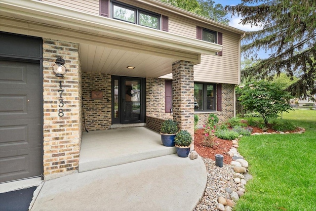 1738 E Jonquil Ter, Arlington Heights, IL 60004 - entrance to property featuring a garage, a yard, a porch, and brick siding