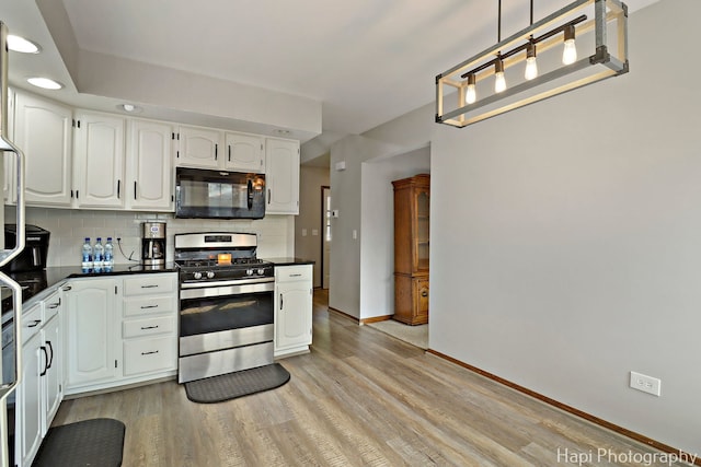 1506 Wilson Ct, Zion, IL 60099 - kitchen featuring stainless steel gas range oven, black microwave, dark countertops, light wood-style flooring, and recessed lighting