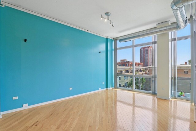 1819 S Michigan Ave Unit 406, Chicago, IL 60616 - unfurnished room featuring a wall of windows, wood finished floors, and a city view