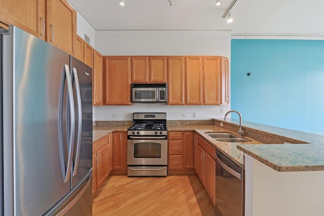 1819 S Michigan Ave Unit 406, Chicago, IL 60616 - kitchen featuring appliances with stainless steel finishes, light wood-style floors, a peninsula, light stone counters, and brown cabinets
