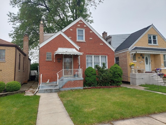 3639 W 69th St, Chicago, IL 60629 - tudor house featuring brick siding, a front lawn, and a chimney