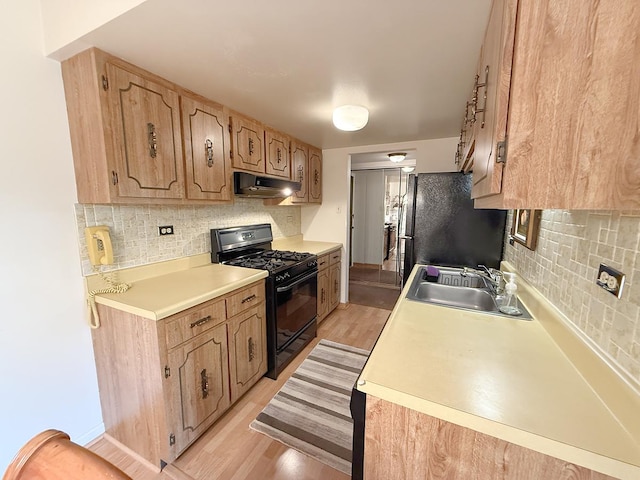 8025 Woodglen Ln Unit 307, Downers Grove, IL 60516 - kitchen with gas stove, freestanding refrigerator, under cabinet range hood, light wood finished floors, and tasteful backsplash