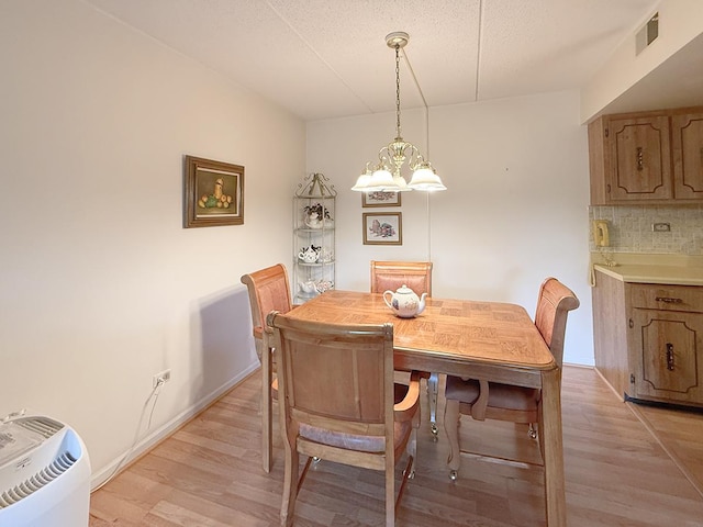 8025 Woodglen Ln Unit 307, Downers Grove, IL 60516 - dining space featuring light wood-type flooring, a chandelier, and a textured ceiling