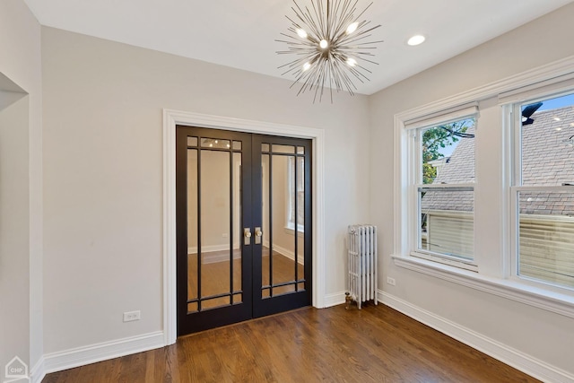 3608 W Dickens Ave Unit 2F, Chicago, IL 60647 - empty room with radiator heating unit, french doors, a chandelier, dark wood-style flooring, and recessed lighting