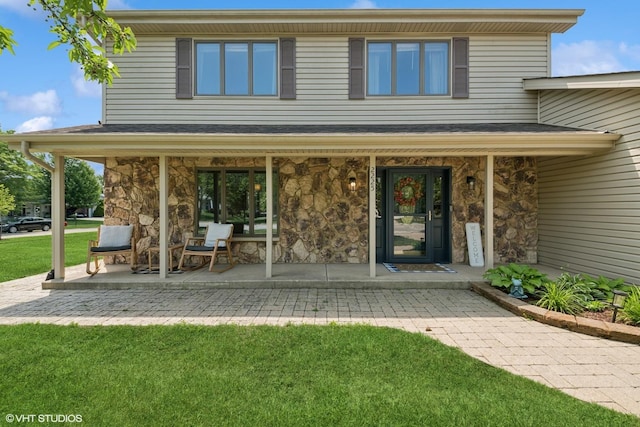 2225 W Weathersfield Way, Schaumburg, IL 60193 - rear view of property with stone siding, a lawn, and covered porch