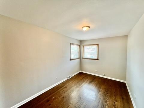 1340 Wesley Ave, Berwyn, IL 60402 - unfurnished room with baseboards and dark wood-type flooring
