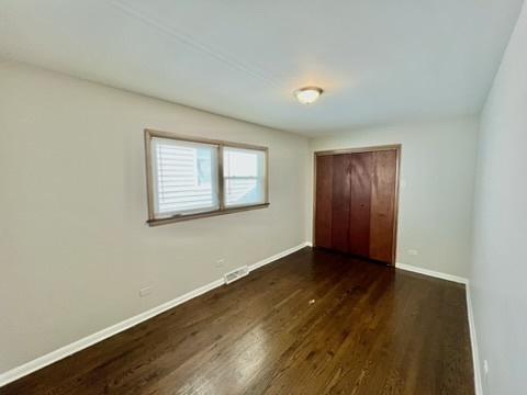 1340 Wesley Ave, Berwyn, IL 60402 - unfurnished bedroom featuring dark wood-style flooring and a closet