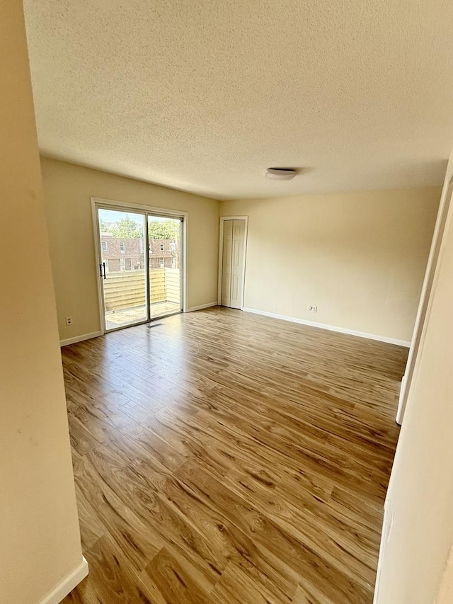 1002 E Harding Dr Unit 303, Urbana, IL 61801 - empty room featuring a textured ceiling and wood finished floors