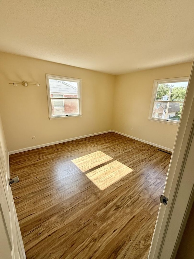 1002 E Harding Dr Unit 303, Urbana, IL 61801 - empty room featuring wood finished floors and a textured ceiling