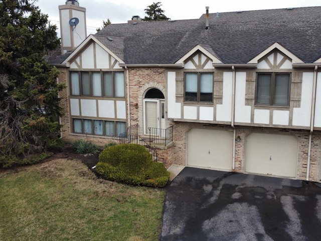 2326 Olde Mill Rd, Plainfield, IL 60586 - tudor-style house with brick siding, a shingled roof, a garage, asphalt driveway, and a front yard