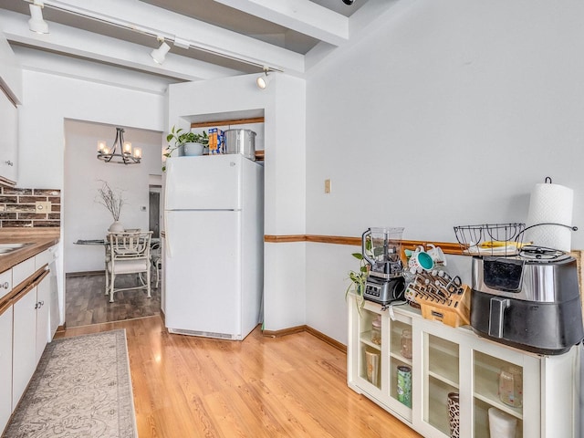 2326 Olde Mill Rd, Plainfield, IL 60586 - kitchen with freestanding refrigerator, a chandelier, white cabinetry, light wood-style floors, and beam ceiling