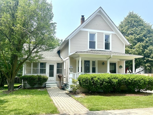 316 N Worth Ave, Elgin, IL 60123 - victorian house featuring covered porch, a chimney, a front yard, and roof with shingles