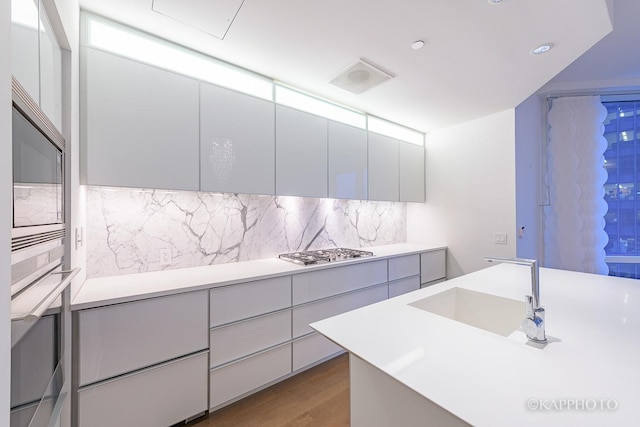 401 N Wabash Ave Unit 39G, Chicago, IL 60611 - kitchen featuring stainless steel appliances, modern cabinets, light countertops, tasteful backsplash, and wood finished floors